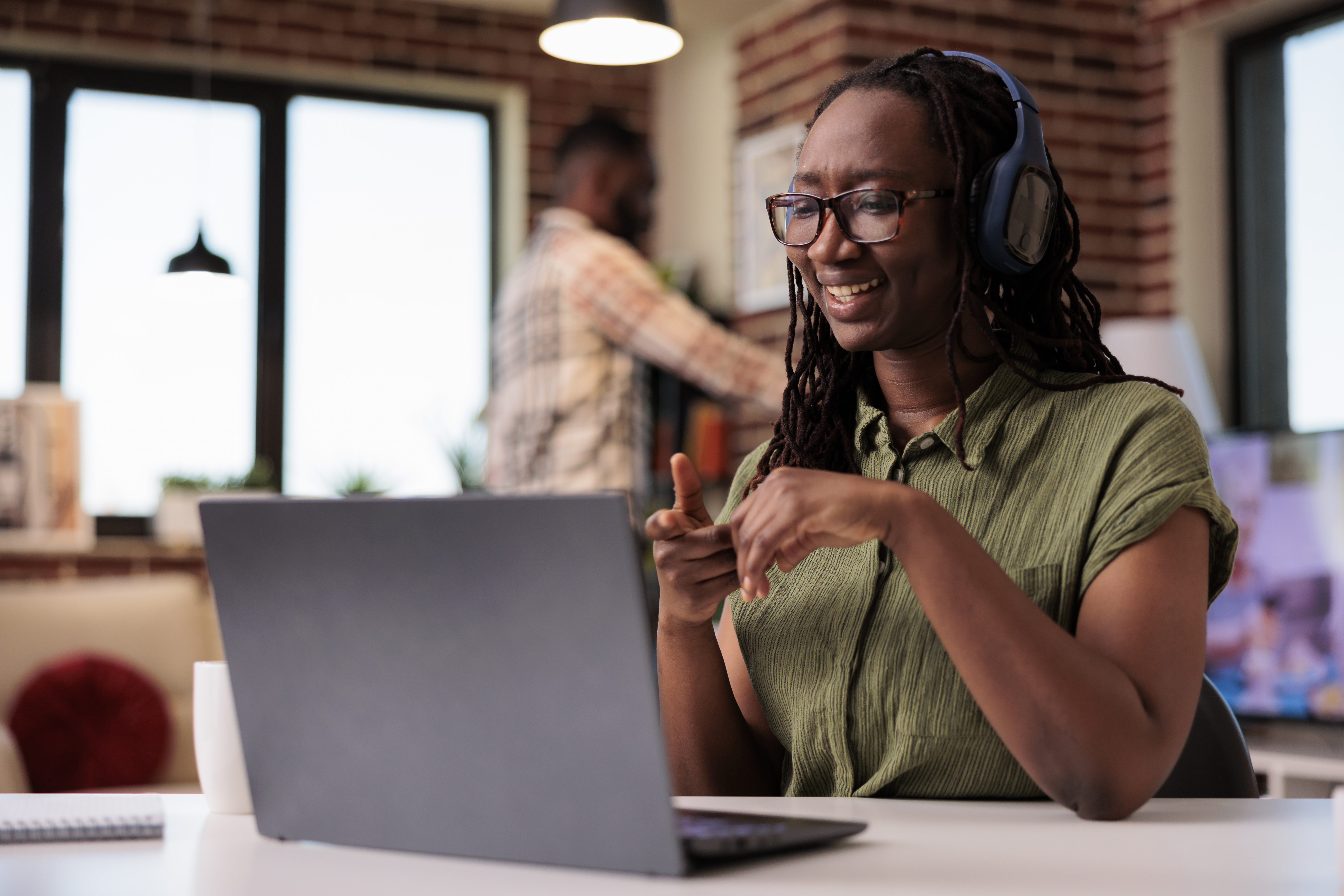 Learner with headphones engaging with a laptop